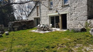 Un bâtiment en pierre doté d’un patio aménagé avec du mobilier d’extérieur.