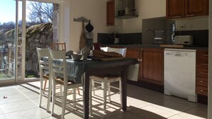 Une cuisine dotée de meubles en bois, d’un lave-vaisselle et d’un coin repas avec des chaises et une table.