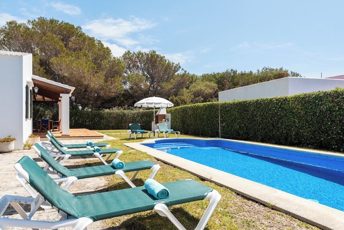 Un espace aménagé au bord de la piscine, avec des chaises longues et une piscine.
