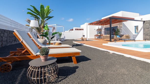 A rooftop terrace with lounge chairs, a small pool, and potted plants.