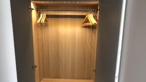 A walk-in closet with wooden paneling, a bench, and hanging clothes. - Elegance and nice view over Cap D'Antibes and beaches (Antibes)