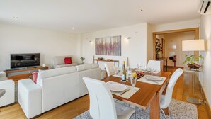 Un salon moderne avec un canapé, une table à manger et un téléviseur.