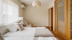Une chambre d’hôtel avec un lit, une table de chevet, une lampe et une armoire.