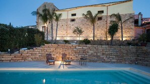 A stone building with a pool and lounge chairs. - Holiday Home in Sicily for 6 People with Pool (Buseto Palizzolo)