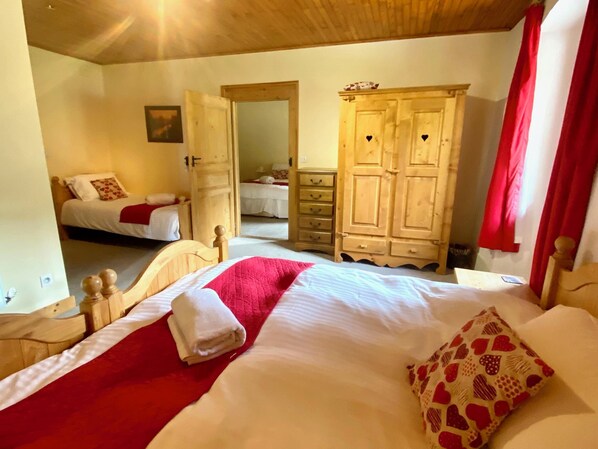 Un dormitorio con una cama grande, un armario de madera y un espejo.