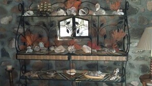 Estante decorativa com diversos objetos e um castiçal.