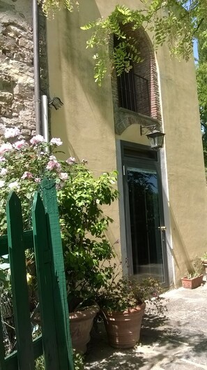 A building with a stone facade, a green gate, and potted plants. - Hilltop paradise cottage, a stone's throw from Florence ! (Scandicci (Firenze))
