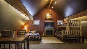 A cozy attic bedroom with a loft bed, a fireplace, a desk, and a laptop. - One Of A Kind Vacation Rental Located By The Base Of Boulder Mountain! (Columbia-Shuswap B)