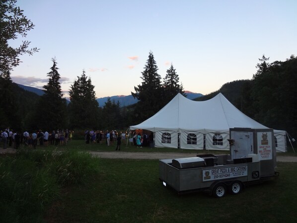 A white tent with a Great Pizza & BBQ Catering truck parked in front.