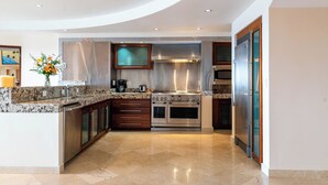 Una cocina moderna con encimeras de granito, electrodomésticos de acero inoxidable y una isla central.