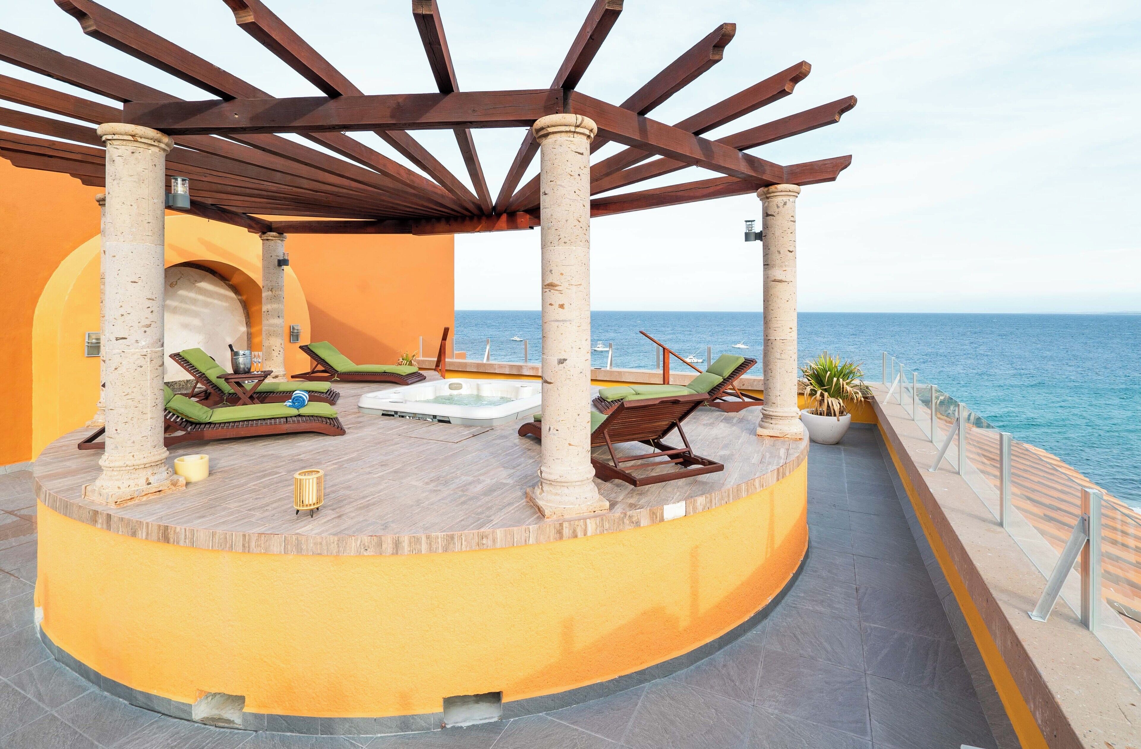 A circular outdoor lounge area with a pool, sun loungers, and a pergola structure.