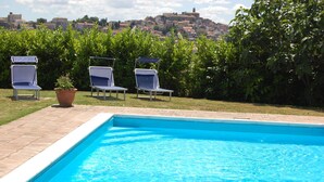 A swimming pool with three lounge chairs and a potted plant. - Fully restored country villa with pool set in private gardens (Castel Frentano)