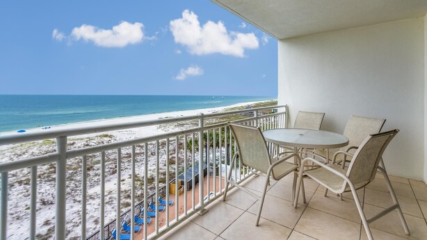 Ein Balkon mit Blick auf Strand und Meer.