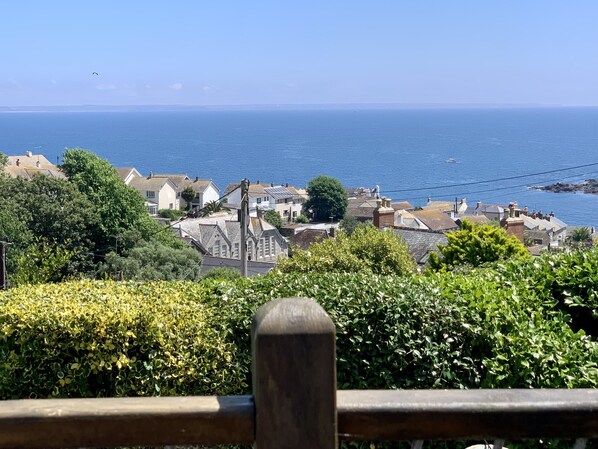 A coastal town with traditional houses, a clear view of the sea, and lush greenery in the foreground. - Cottage With Fabulous Views, Garden, Deck, Private Off Road Parking & EV Charger (Mousehole)