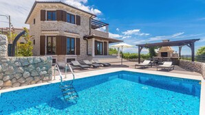 A two-story stone house with a swimming pool, outdoor seating, and a barbecue area. - Villa CAVALLO with pool and sea view (Linardići)