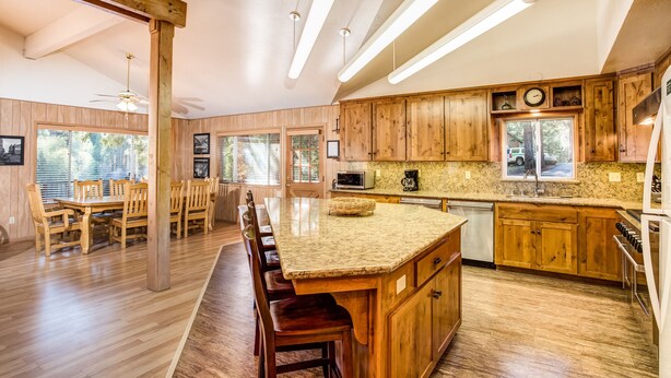 A spacious kitchen with wooden cabinets, a large island, and modern lighting. - (64) River Lodge at The Redwoods In Yosemite (Yosemite National Park)