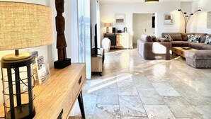 Ein modernes Wohnzimmer mit Couch, Lampenschirm und einem Holztisch.