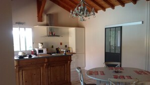 A kitchen with wooden cabinets, a white countertop, a microwave, and a chandelier. - Studio beautiful view of the Pyrenees  (Souraïde)