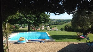 A swimming pool with a deck, surrounded by a grassy area and trees. - Studio beautiful view of the Pyrenees  (Souraïde)