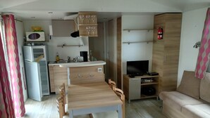 A compact living space with a kitchenette, a dining area, and a seating area.