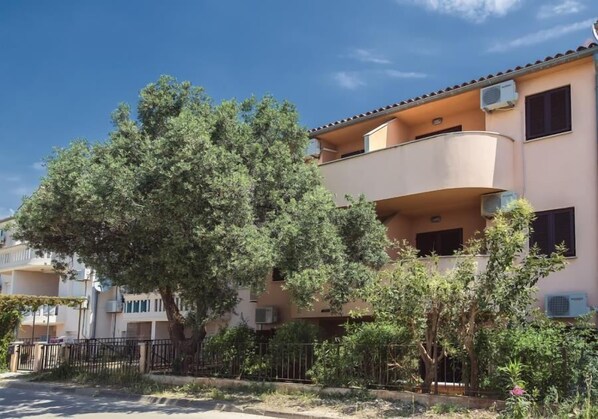 A residential building with a balcony, air conditioning units, and a tree in the foreground. - Only 100 meters to the beach with air conditioning and WiFi (Medulin)