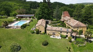 A large stone house with a swimming pool, surrounded by lush greenery and hills. - -Domaine de Cournet Haut-Le Saule: featuring a pool, tennis court, and bicycles on 5 hectares (Saint-Pompont)