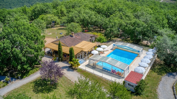 An aerial view of a property with a swimming pool, covered outdoor seating area, and a small building. - Vacation rental in self-catering village with heated swimming pool near Sarlat (Orliaguet)