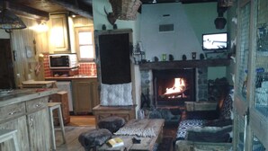 Una sala de estar acogedora con chimenea, muebles de madera y televisor.