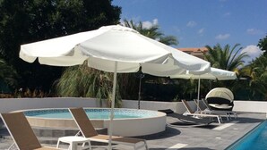 A poolside area with lounge chairs and umbrellas. - Turquoise apartment 4/5 people (San-Nicolao)