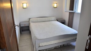 A bedroom with a bed, two bedside tables, a nightstand, a window, and wall-mounted lights. - Turquoise apartment 4/5 people (San-Nicolao)