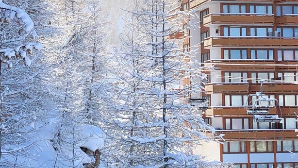 A multi-story building with a modern architectural design, surrounded by snow-covered trees. - Châlet located in PLAGNE Centre, rated 4 Paradiski crystals and furnished for tourism, (La Plagne Tarentaise)