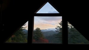 Une fenêtre triangulaire donnant sur un paysage montagneux.