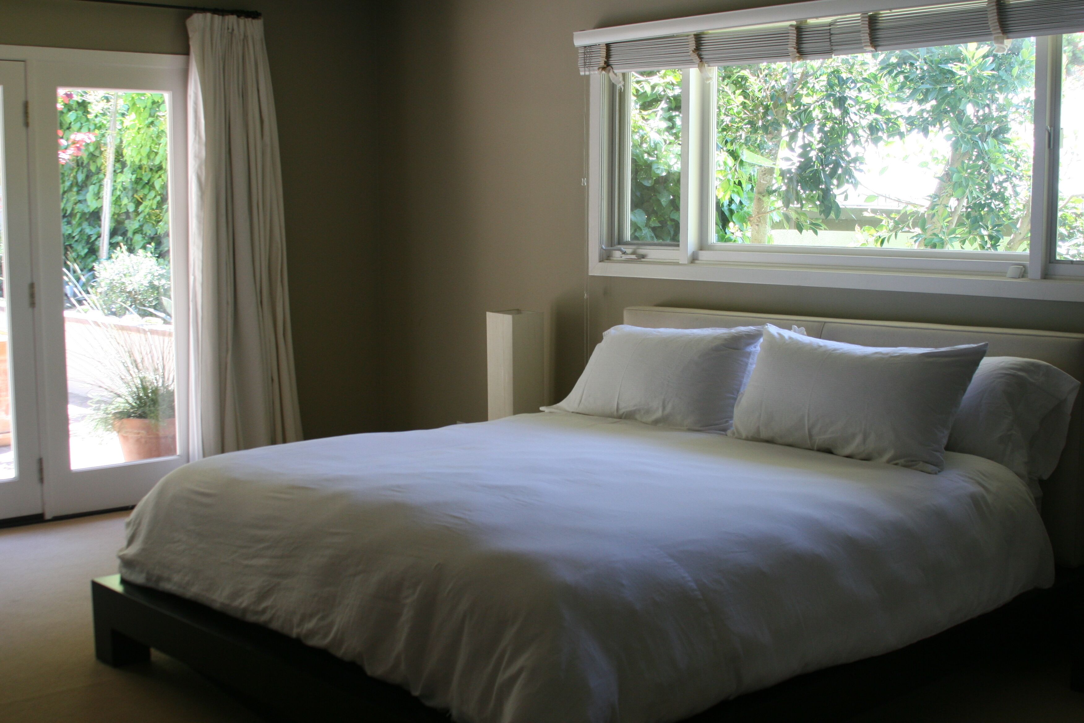 Master bedroom with view of pool and backyard