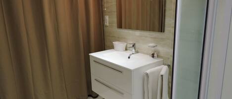 A bathroom with a white sink, mirror, and towel hanging on the wall.