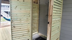 A wooden door with horizontal slats, a metal door handle, and a small vent.