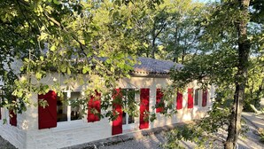 Ein Gebäude mit roten Fensterläden und einer Auffahrt mit Kies.