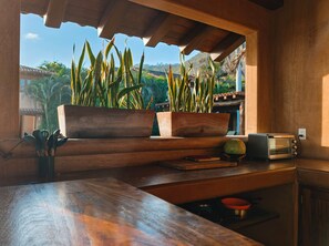 A kitchen with wooden countertops, a toaster, and potted plants.