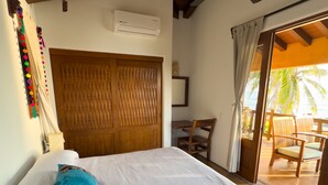 Un dormitorio con cama, ventilador de techo, puerta de madera y vistas al exterior.