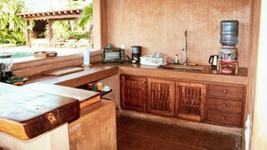 Una cocina con mostrador de madera, una cafetera y un dispensador de agua.