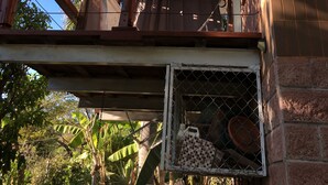 Ein Balkon mit Holzgeländer, Deckenventilator und Fenstergitter.