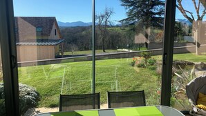 A room with a large sliding glass door leading to a grassy yard with a mountain view.