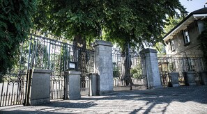 Une grille en fer forgé, flanquée de piliers en pierre, marque l’entrée des jardins botaniques nationaux.