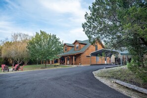 Relax in a serene log cabin-style retreat surrounded by a well-manicured lawn and lush greenery.