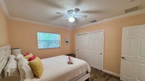 A bedroom with a bed, a ceiling fan, a window with blinds, and a door. - 2-Bedroom Apartment Just A Short Walk To Deerfield Beach Pier (Deerfield Beach)