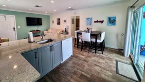 A modern kitchen with granite countertops, a built-in dishwasher, and a dining area with a table and chairs. - 2-Bedroom Apartment Just A Short Walk To Deerfield Beach Pier (Deerfield Beach)