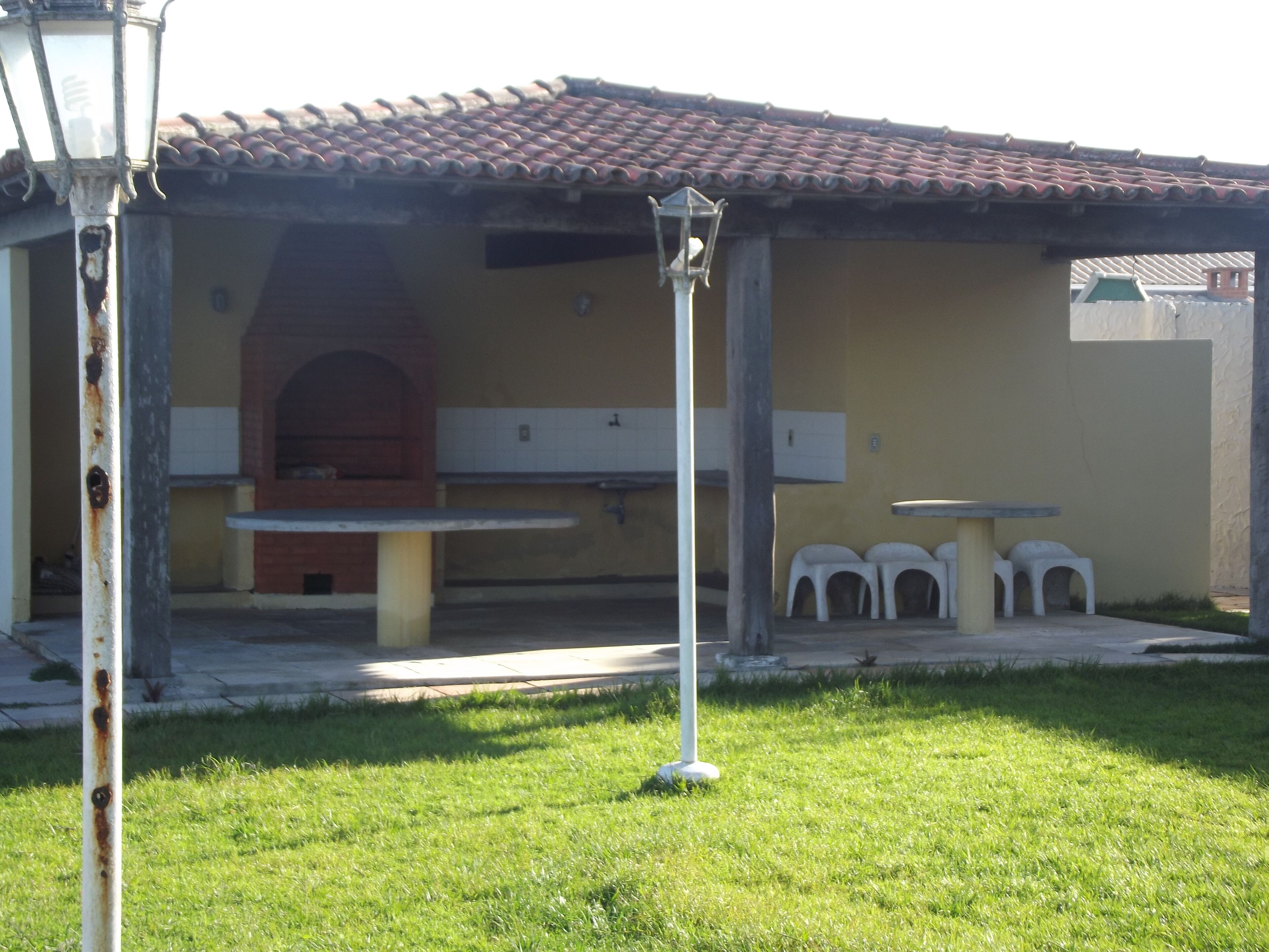 A patio area with a brick oven, outdoor seating, and a lamp post.