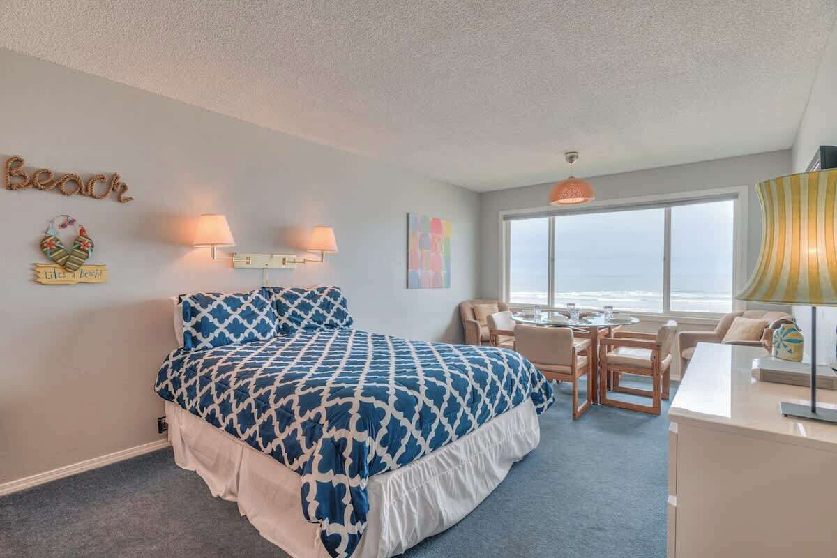 Ein Schlafzimmer mit einem großen Bett, einem Schreibtisch, einem Stuhl und Meerblick.