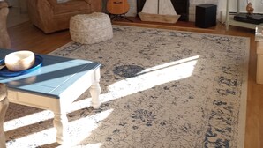 Ein Wohnzimmer mit Kamin, Gitarre und Fernseher.