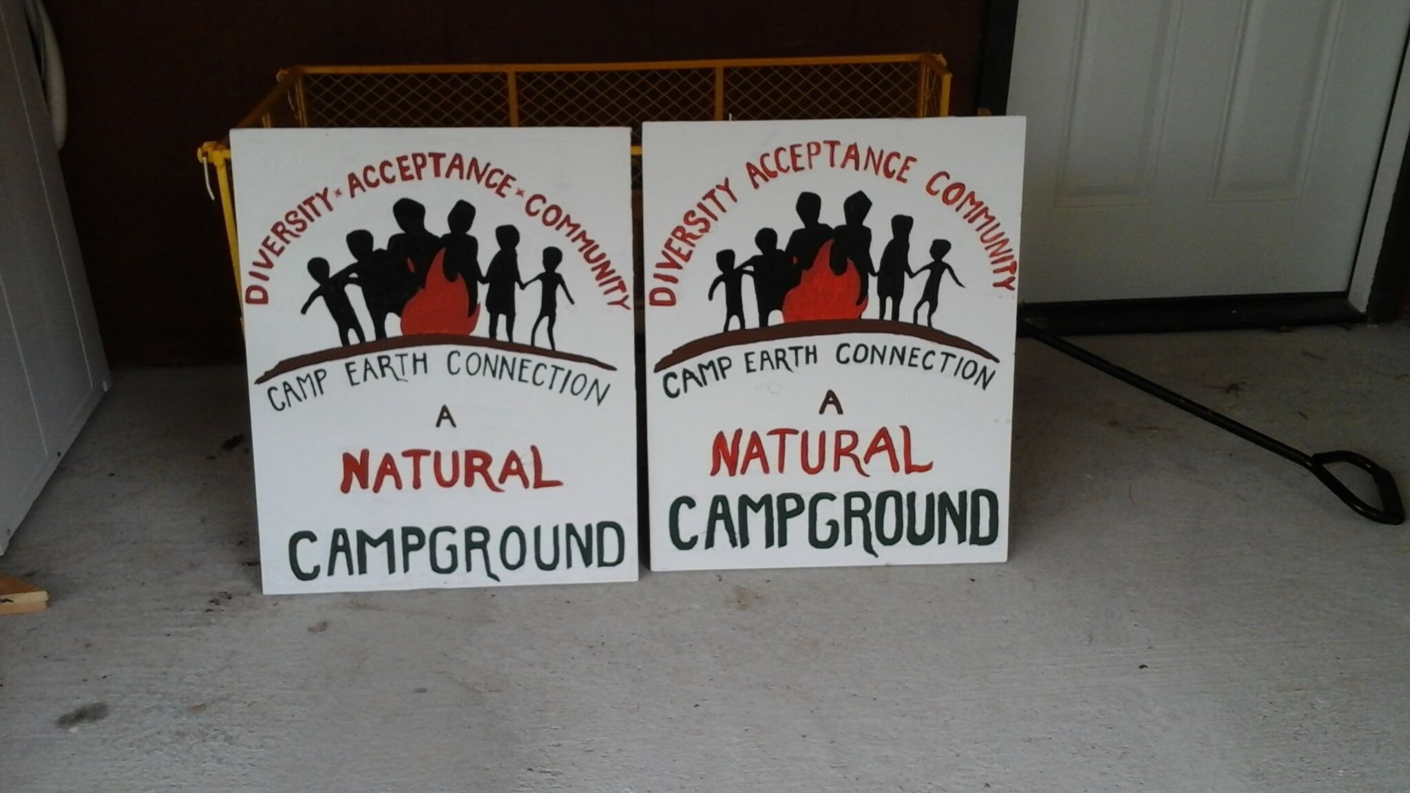 Two signs for a natural campground with diversity and community acceptance messages.