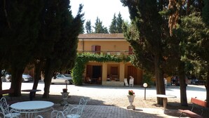 An outdoor patio area with white metal chairs and tables, surrounded by trees. - Villa degli Scoiattoli, 200-m² villa for 8-10 people with park and swimming pool (Casette D'ete, FM)